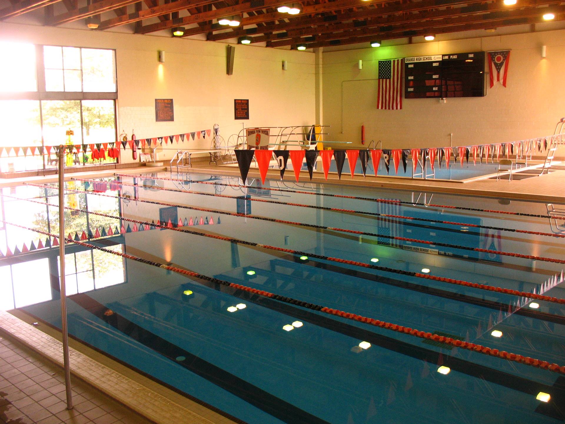 A picture of an empty indoor pool with orange and black flags 