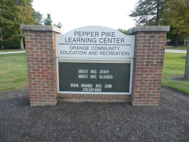 Outdoor sign saying "Pepper Pike Learning Center Orange Community Education and Recreation" with bri