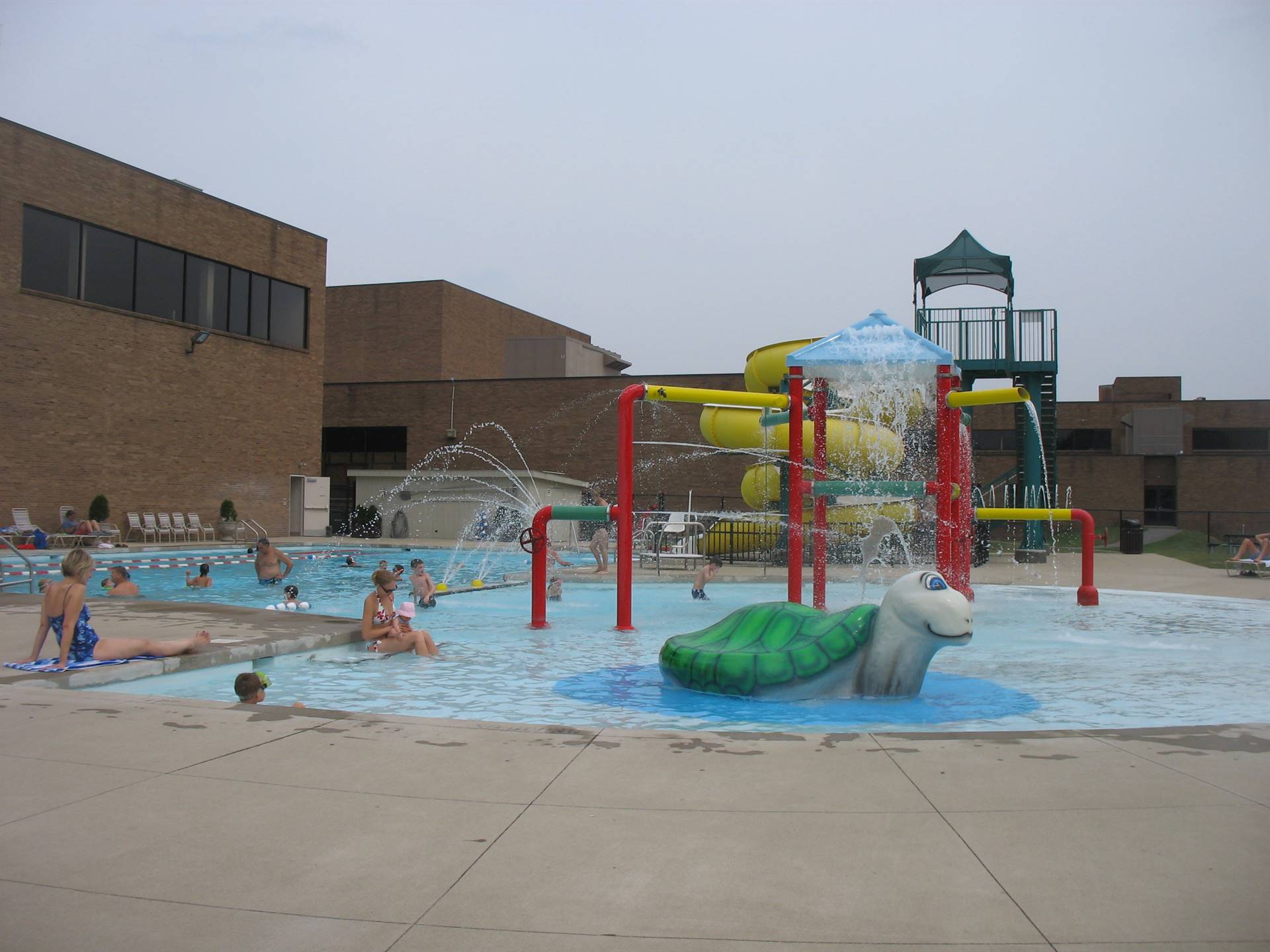 Outdoor pool with people swimming and the water features turned on 